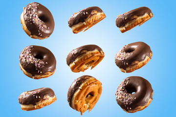 Chocolate glazed doghnut with sprinkled sweets on top on blue background. High resolution image for food industry.
