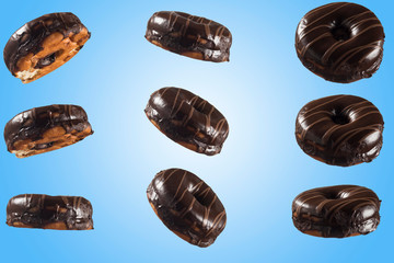 Chocolate glazed doghnut with chocolate milk lines on blue background. High resolution image for food industry.