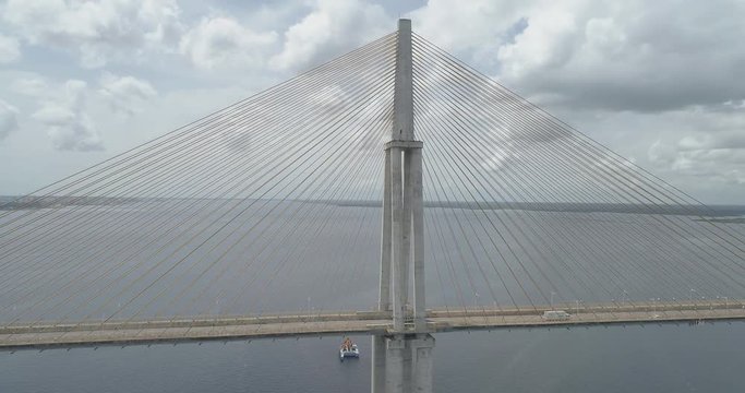 Low aerial beside cars crossing the cable-stayed Rio Negro Bridge that links the cities of Manaus and Iranduba in the Brazilian Amazon