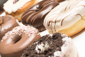 Multiple doughnuts on white background. High resolution image for food industry.