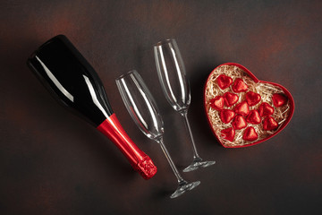 Valentine's Day with a bottle of champagne glasses Red box of chocolates in the shape of a heart....