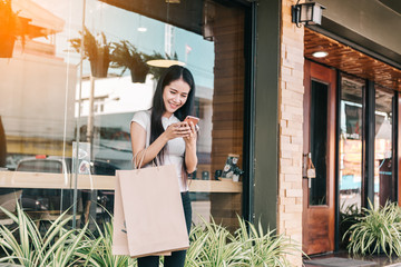 young woman texting while enjoying a day shopping