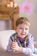Fototapeta premium Funny boy sitting on the armchair