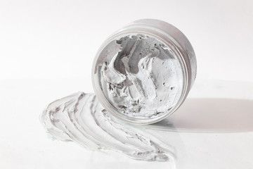 Natural face mask. Smear Clay Mask for face and container with mask on a light background with a shadow. - 245454141