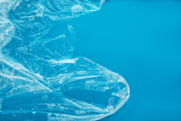 Plastic bag floating on surface of blue water, top view. Pollution concept