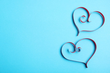 Hearts made of paper strips on color background, top view. Space for text