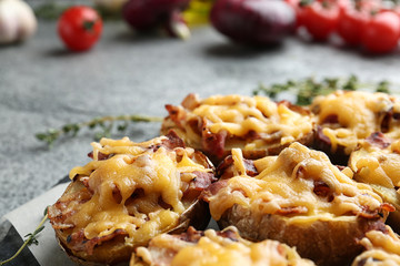 Baked potatoes with cheese and bacon on table, closeup