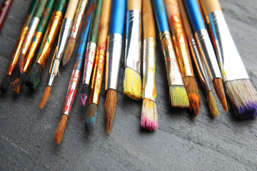 Fototapeta premium Different paint brushes on grey table, closeup