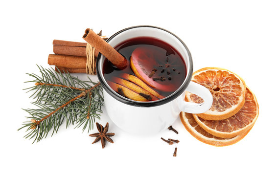 Composition with mug of mulled wine, cinnamon, orange and fir branch on white background
