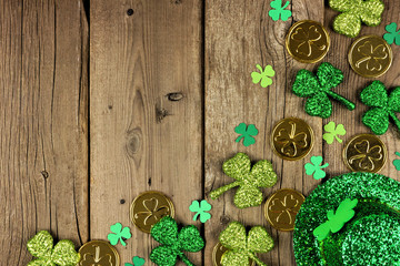 St Patricks Day corner border with green shamrocks, gold coins and leprechaun hat over a rustic wood background