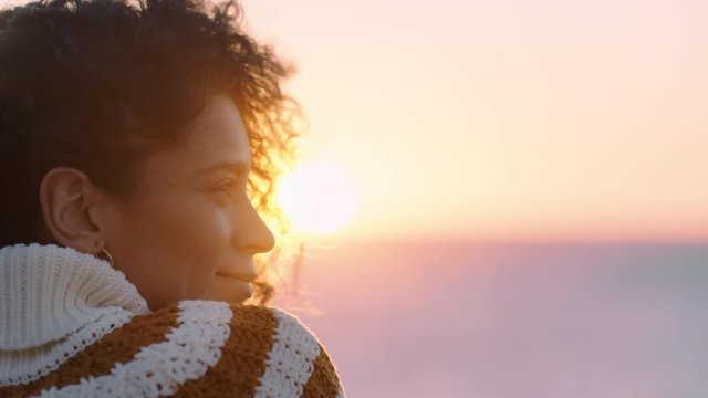 portrait of beautiful hispanic woman enjoying peaceful seaside at sunset exploring mindfulness contemplating spirituality with wind blowing hair