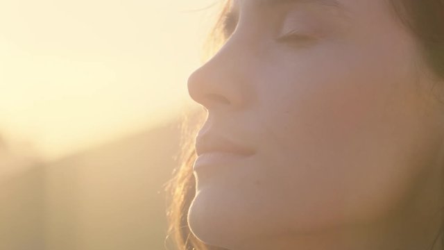 close up portrait of beautiful woman enjoying peaceful sunset exploring spirituality looking up praying contemplating journey with wind blowing hair