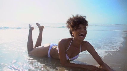 Attractive African American girl in swimwear relaxing on Summer holiday resort