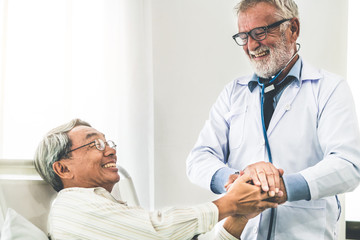 Mature doctor talking and examining health of senior patient in hospital ward. Medical healthcare...