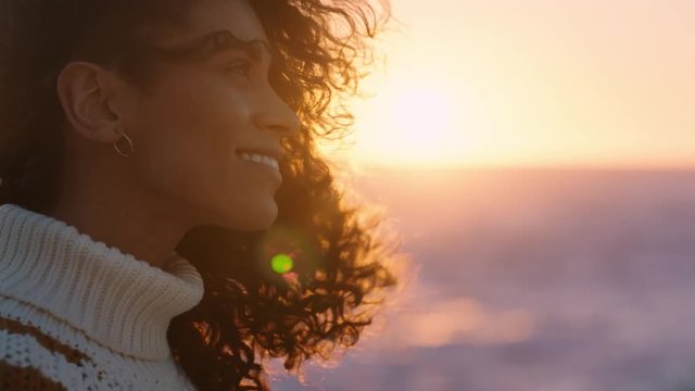 portrait of beautiful hispanic woman enjoying peaceful seaside at sunset exploring mindfulness contemplating spirituality with wind blowing hair