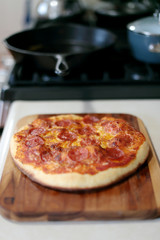 Freshly baked homemade pepperoni pizza in cast iron pan from the oven.
