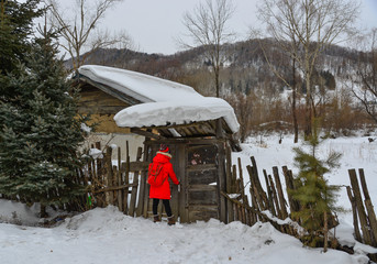 A woman in red coat standing at village