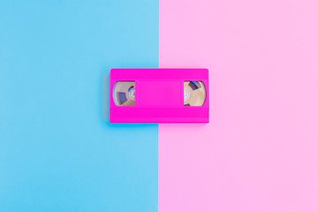VHS cassette on soft pink and blue paper background. Minimal concept. Creative concept. Cinema concept. 