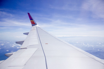 Fototapeta na wymiar Wing of the plane on sky background