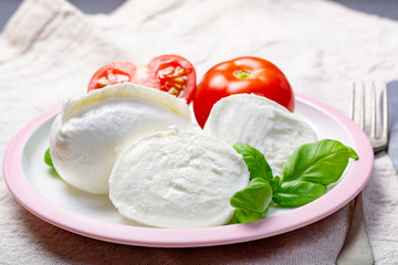 Soft white Italian cheese Mozzarella buffalo served with fresh tomato and green basil leaves