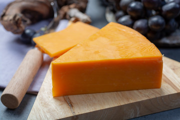 Piece of hard orange Cheddar cheese close up