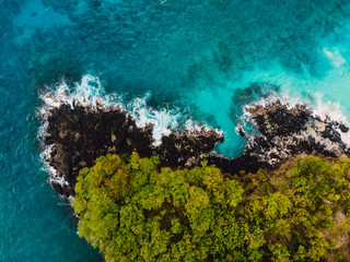 Blue ocean in tropics with rocky coast. Aerial view.