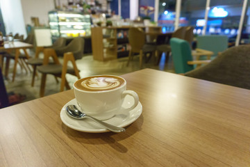 Cappuccino or Latte coffee art cup with heart shaped surface, top view of Cappuccino or Latte Coffee art cup ( Image take in low light condition)