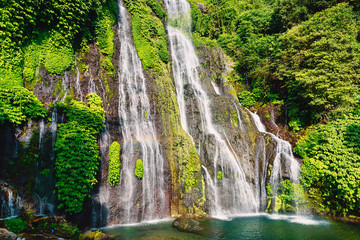 Waterfall with crystal water and rainbow in tropical island. Bali, Indonesia