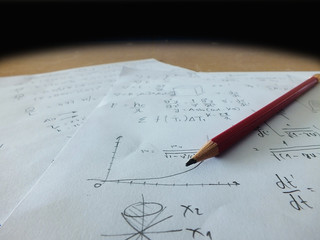 A close up mathematical equations on a sheet of paper