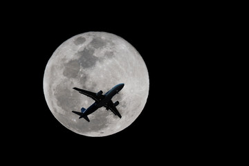 an airplane flying across a full moon, Silhouettes of Aircraft and super moon
