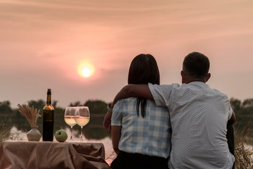 Happy life moments. Couple enjoying the sunset while having a glass of wine