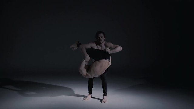 Young Caucasian American stunt men in harmony acrobatic yoga figure