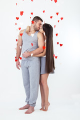 Valentines day lovely caucasian couple staying white background and red heart air around. celebration isolated