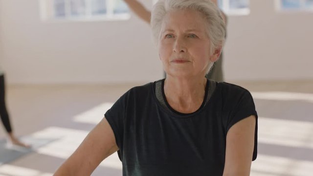 yoga class beautiful elderly woman exercising healthy lifestyle practicing warrior pose enjoying group fitness workout in studio