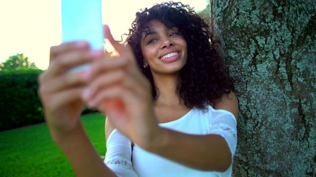 Smiling African American woman making video diary in the park