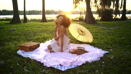 Attractive African American girl flirting on social media at picnic light flare