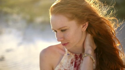 Female redhead on the beach making video diary USA