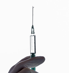 a hand with glove holds a syringe for vaccination