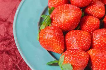 valentines red strawberries in teal blue dish with melted bitter chocolate