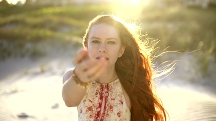 Female redhead on the beach making video diary USA