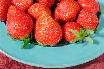 valentines red strawberries in teal blue dish with melted bitter chocolate