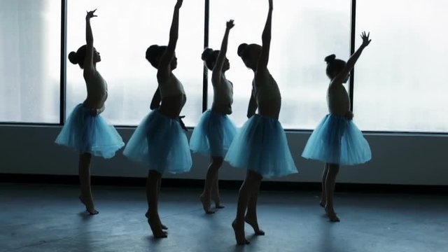 Young ballet dancers in dance school in silhouette