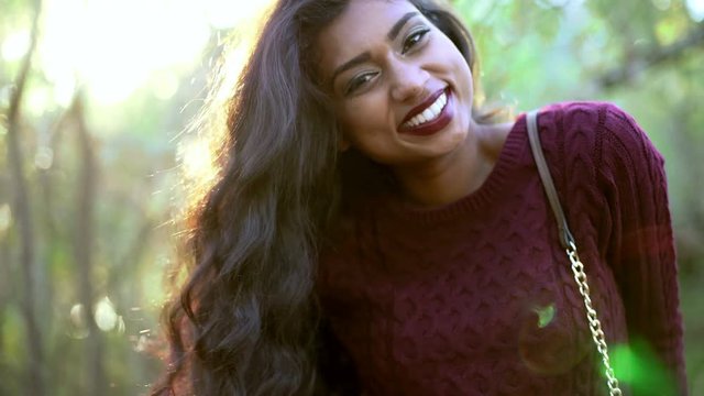 Portrait for a video library of pretty Indian Asian girl posing in the park