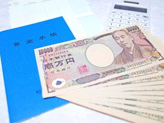 お金（一万円札）と年金手帳