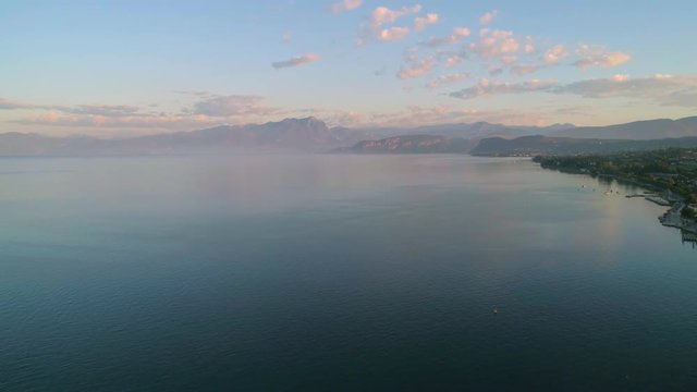 Lake Garda, C4k aerial, drone shot, of the coast of lago di Garda, near lazise fortress, on a sunny, summer morning dawn, in Veron, Italy