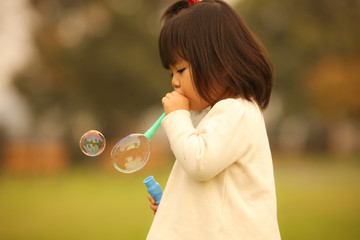 シャボン玉で遊ぶ女の子
