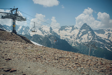 chair lift on the background of snowy mountain peaks, Sunny day