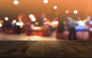 Empty dark wooden table in front of abstract blurred bokeh background of restaurant . can be used for display or montage your products.Mock up for space.