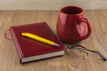 Drowsiness : diary, glasses, and a red mug of strong coffee on t