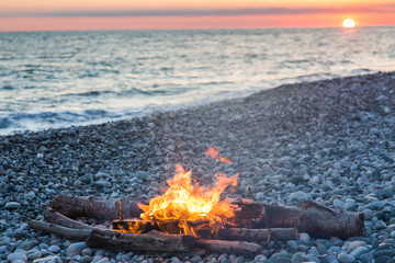 bonfire on the pebble seaside at sunset © Nikita
